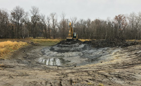 Excavator digging in a mud pit